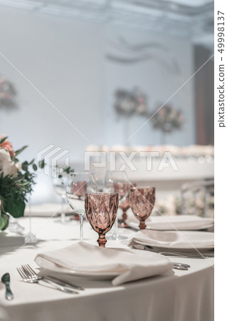 Glasses of wine on round Banquet table served. Interior of restaurant for wedding dinner, ready for 49998137