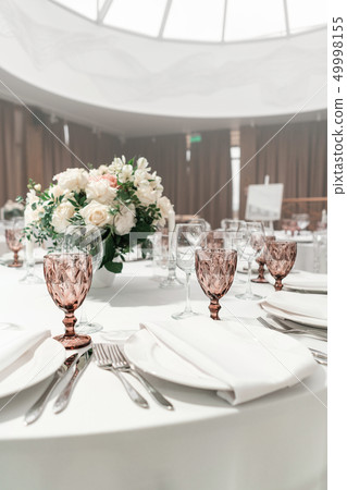 Wine glasses on round Banquet table served. Interior of restaurant for wedding dinner, ready for Wine glasses on round Banquet table served. Interior of restaurant for wedding dinner, ready for 49998155