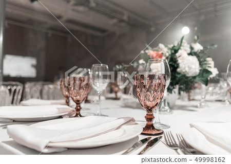 Wine glasses on round Banquet table served. Interior of restaurant for wedding dinner, ready for Wine glasses on round Banquet table served. Interior of restaurant for wedding dinner, ready for 49998162