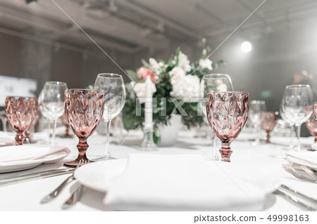 Wine glasses on round Banquet table served. Interior of restaurant for wedding dinner, ready for Wine glasses on round Banquet table served. Interior of restaurant for wedding dinner, ready for 49998163