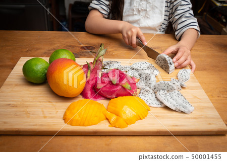 Girl cutting dragon fruit 50001455