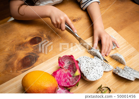 Girl cutting dragon fruit Girl cutting dragon fruit 50001456