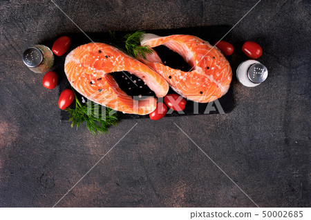 Fresh two raw salmon steaks on dark background 50002685