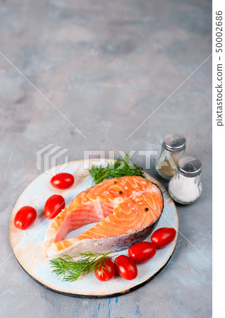 Vertical shot of fresh salmon steak with tomatoes 50002686