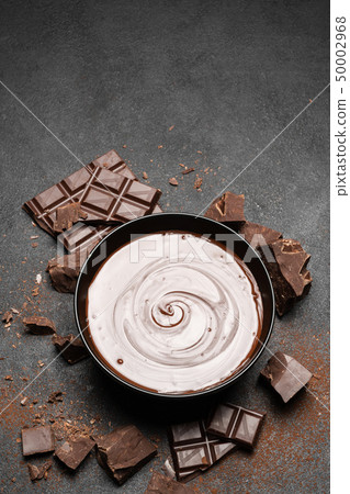 ceramic bowl of chocolate cream or melted chocolate and pieces of chocolate isolated on dark ceramic bowl of chocolate cream or melted chocolate and pieces of chocolate isolated on dark 50002968