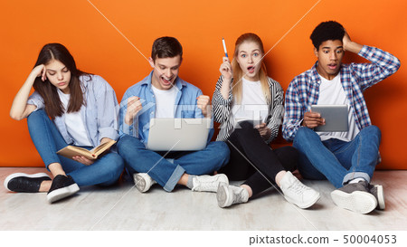 Exam preparation. Students with gadgets and books 50004053