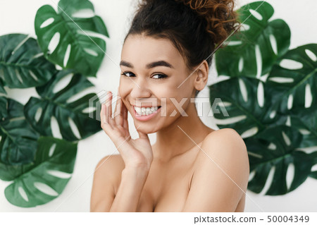 Natural cosmetics. Sensual woman against tropical leaves Natural cosmetics. Sensual woman against tropical leaves 50004349
