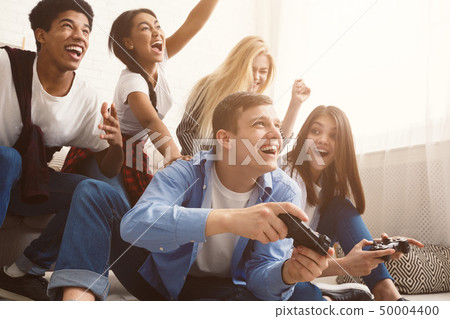 Teenagers having fun, playing video games online 50004400