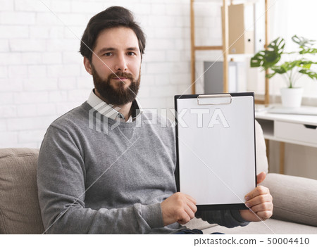 Confident psychotherapist showing white blank clipboard at camera 50004410