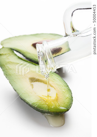 Avocado with oil on white 50004453