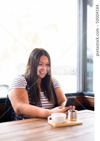 Beautiful overweight Asian woman relaxing at the coffee shop Beautiful overweight Asian woman relaxing at the coffee shop 50004584