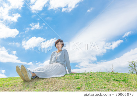 Under the blue sky Refreshing alafour woman on the grass hill Under the blue sky Refreshing alafour woman on the grass hill 50005073
