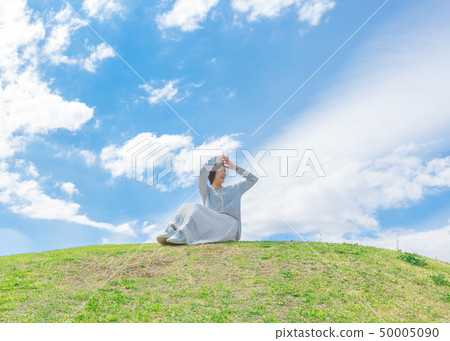 Under the blue sky Refreshing alafour woman on the grass hill 50005090