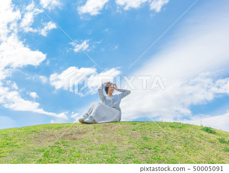 Under the blue sky Refreshing alafour woman on the grass hill Under the blue sky Refreshing alafour woman on the grass hill 50005091