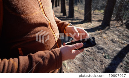 theme tourism and technology. Young caucasian man with beard and backpack. Hiking tourist in pine 50007917