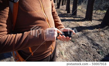 theme tourism and technology. Young caucasian man with beard and backpack. Hiking tourist in pine 50007918