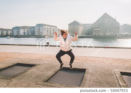 adult person rejoices like child. Playground trampoline in ground, children trampoline, springs 50007933