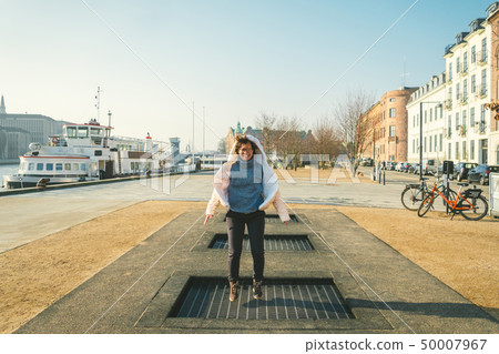 adult person rejoices like child. Playground trampoline in ground, children trampoline, springs 50007967