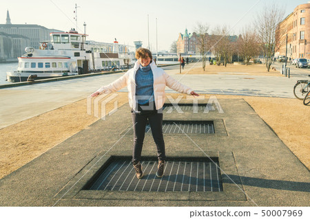 adult person rejoices like child. Playground trampoline in ground, children trampoline, springs 50007969