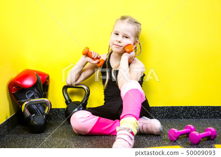 Theme sports and health children. Little funny child Caucasian girl with pigtails, sits resting Theme sports and health children. Little funny child Caucasian girl with pigtails, sits resting 50009093