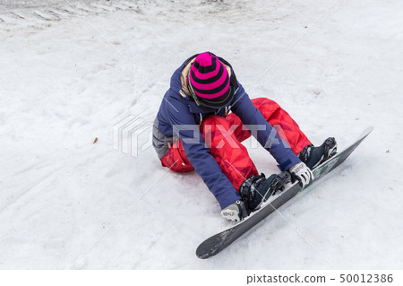 A woman wearing a snowboard 50012386