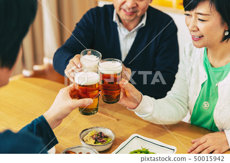 Family group dinner evening toast 50015942