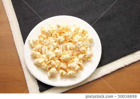 Popcorn served in a paper plate. 50016699