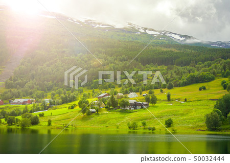 Village is located on the green slopes near lake. 50032444