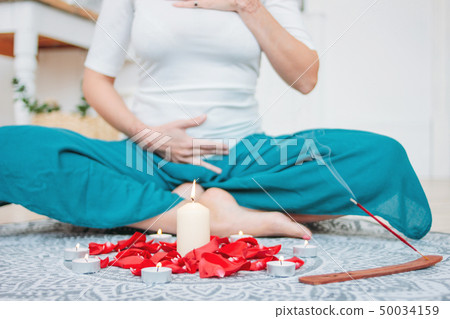 Woman in ethnic costume practicing yoga in front 50034159