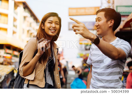 Young tourist asking for directions from local people 50034399
