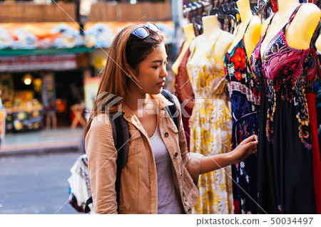 Young woman browsing clothes in the market Young woman browsing clothes in the market 50034497