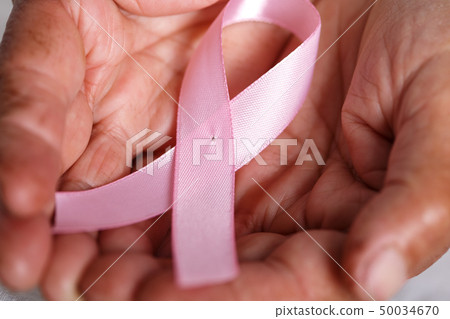 Elder woman hands holding pink ribbon Elder woman hands holding pink ribbon 50034670