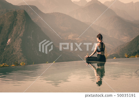woman practice yoga Lotus pose on the pool 50035191