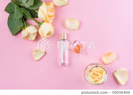 Perfume bottles with flowers on pink background. Perfumery, cosmetics, fragrance collection. Flat Perfume bottles with flowers on pink background. Perfumery, cosmetics, fragrance collection. Flat 50036409