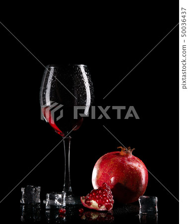Pomegranate juice in a glass on a black Pomegranate juice in a glass on a black 50036437