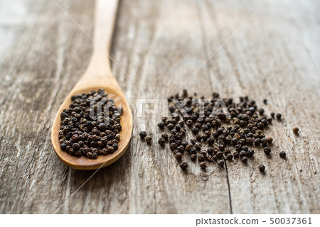 Black pepper in a wooden spoon Black pepper in a wooden spoon 50037361
