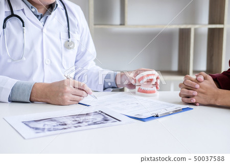 Male doctor or dentist writing report working with Male doctor or dentist writing report working with 50037588