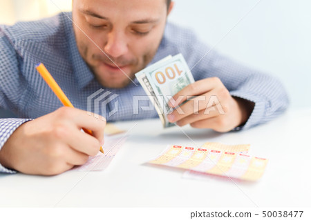 Photo of male filling out lottery ticket and euro. Photo of male filling out lottery ticket and euro. 50038477