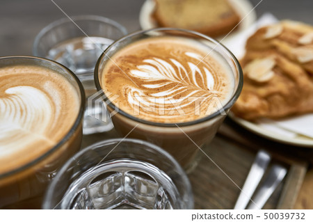 Milk coffee with croissant and bread and water on wooden table Milk coffee with croissant and bread and water on wooden table 50039732
