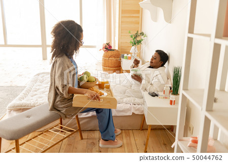 Patient lying in bed and enjoying breakfast talking to nurse Patient lying in bed and enjoying breakfast talking to nurse 50044762