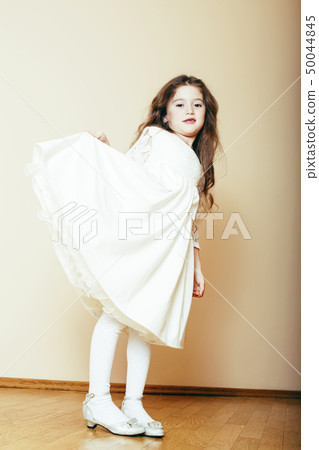 little cute girl with long curly hair posing cheerful on white background, lifestyle people concept 50044845