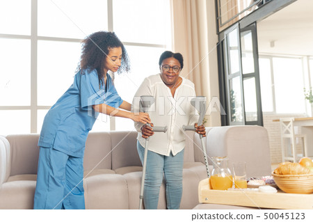 Woman feeling satisfied after making first steps after surgery on legs 50045123