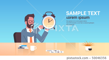 happy businessman holding alarm antique clock business man sitting workplace desk deadline time happy businessman holding alarm antique clock business man sitting workplace desk deadline time 50046356