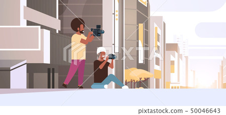 photographer and cameraman using cameras shooting video taking pictures working together over modern 50046643