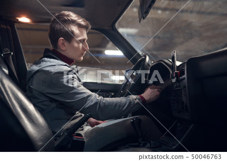 Photo from side of man sitting in car . 50046763