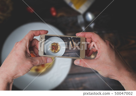 Man taking photo of Italian spaghetti bolognese Man taking photo of Italian spaghetti bolognese 50047002