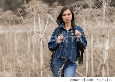 Portrait of a girl in jeans in the field 50047120