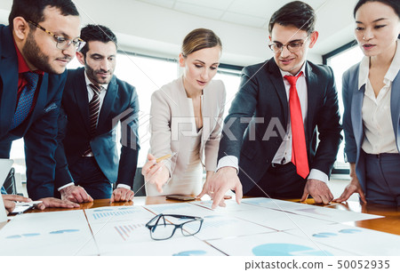 Team of business people analyzing numbers and charts Team of business people analyzing numbers and charts 50052935