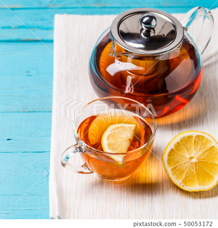 Glass cup of tea with lemon and glass teapot. Glass cup of tea with lemon and glass teapot. 50053172