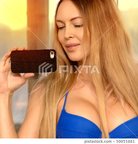 A beautiful girl with long light brown hair holds 50055881